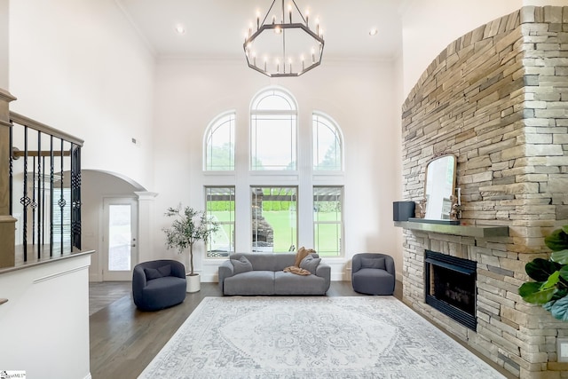 740 N Alamosa Dr, Boiling Springs, SC 29316 - living area featuring a stone fireplace, arched walkways, wood finished floors, a chandelier, and a high ceiling
