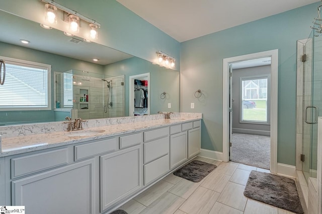 2 Stony Run Ln, Simpsonville, SC 29681 - bathroom with a stall shower, double vanity, a walk in closet, and baseboards