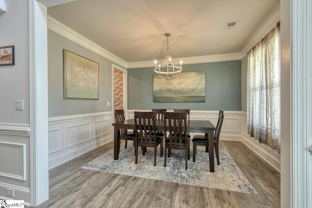 2 Stony Run Ln, Simpsonville, SC 29681 - dining area featuring a chandelier, crown molding, wood finished floors, a decorative wall, and wainscoting