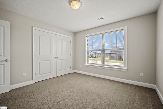 157 Deyoung Meadows Dr, Greer, SC 29651 - unfurnished bedroom with carpet floors, a closet, baseboards, and a textured ceiling