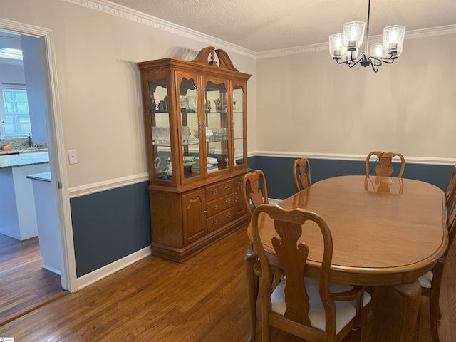 111 Firethorne Ct, Greer, SC 29650 - dining room featuring wood finished floors, a chandelier, crown molding, baseboards, and a textured ceiling