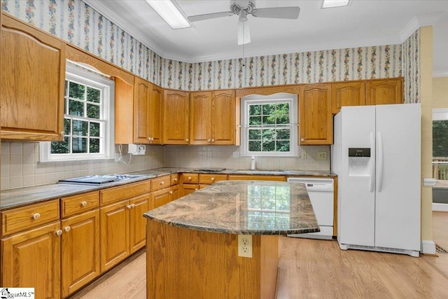 107 Cinder Creek Ln, Spartanburg, SC 29307 - kitchen featuring white appliances, light wood-type flooring, dark stone counters, brown cabinets, and wallpapered walls