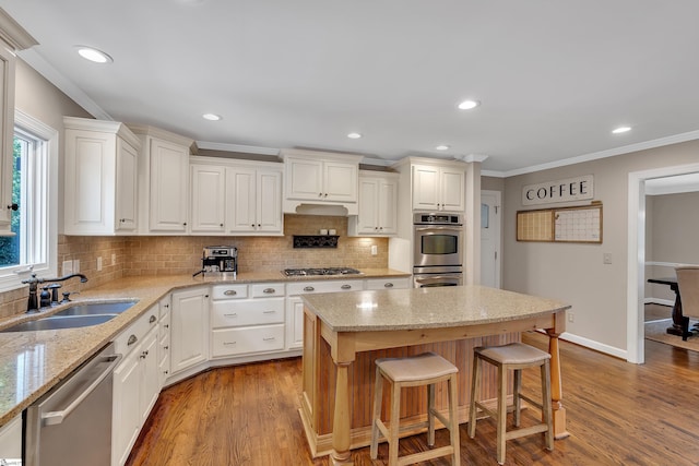 103 Brandon Way, Simpsonville, SC 29681 - kitchen with stainless steel appliances, a sink, ornamental molding, decorative backsplash, and a kitchen bar