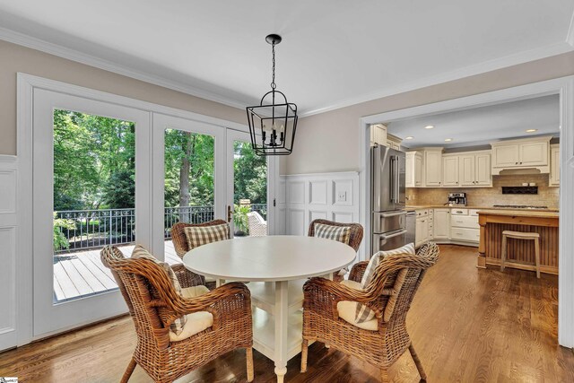 103 Brandon Way, Simpsonville, SC 29681 - dining area featuring a chandelier, crown molding, a decorative wall, wood finished floors, and a wainscoted wall