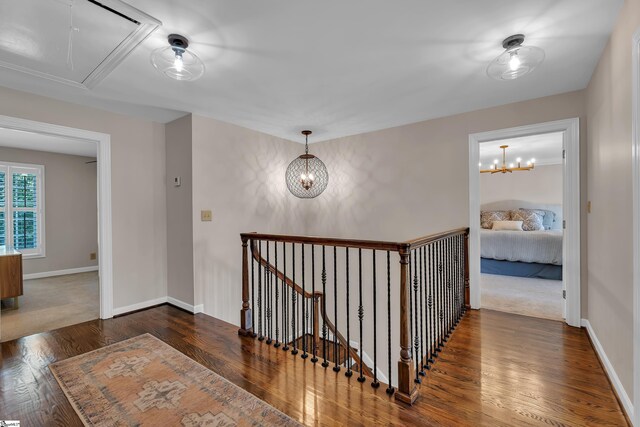 103 Brandon Way, Simpsonville, SC 29681 - hallway featuring attic access, an upstairs landing, wood finished floors, baseboards, and a chandelier