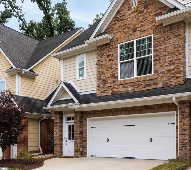 19 Edge Ct Unit A, Greenville, SC 29609 - view of front of property with stone siding, an attached garage, concrete driveway, and a shingled roof