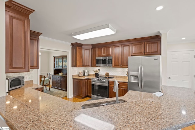 4 Jester Ct, Simpsonville, SC 29681 - kitchen featuring appliances with stainless steel finishes, a sink, ornamental molding, light stone counters, and tasteful backsplash