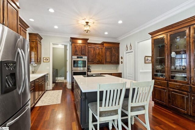 5 Fife Ct, Simpsonville, SC 29681 - kitchen featuring appliances with stainless steel finishes, light countertops, dark wood-style floors, a center island, and ornamental molding
