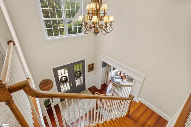 5 Fife Ct, Simpsonville, SC 29681 - stairway featuring a chandelier, french doors, wood finished floors, a towering ceiling, and baseboards