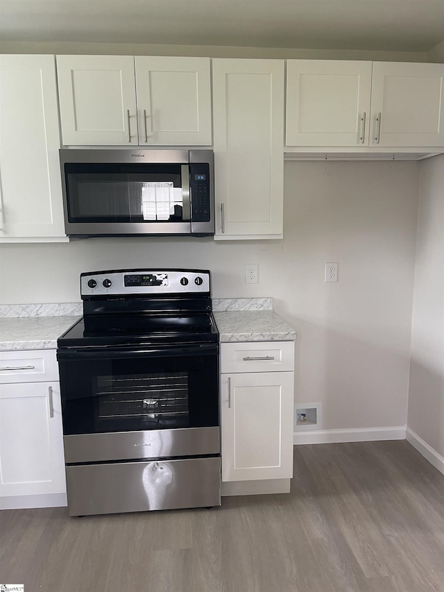 400 Mason Rd, Inman, SC 29349 - kitchen with stainless steel appliances, baseboards, light wood-type flooring, and white cabinetry