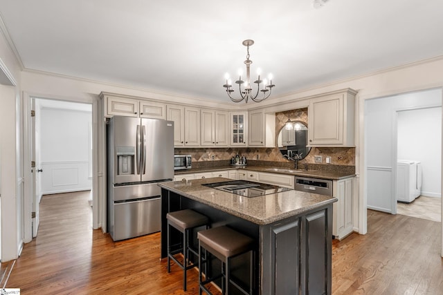 119 Circle Slope Dr, Simpsonville, SC 29681 - kitchen featuring stainless steel appliances, a chandelier, washer / dryer, tasteful backsplash, and crown molding
