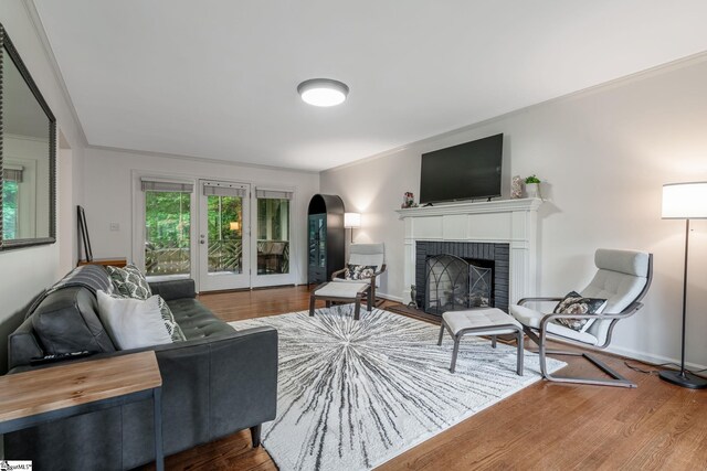 119 Circle Slope Dr, Simpsonville, SC 29681 - living room featuring a brick fireplace, wood finished floors, arched walkways, baseboards, and crown molding