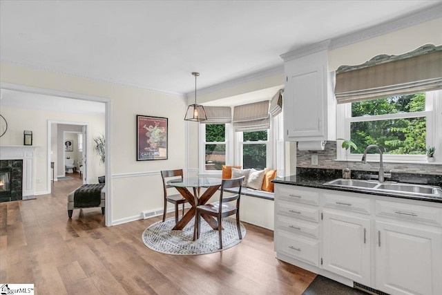 16 Chariot Ln, Simpsonville, SC 29681 - kitchen featuring a sink, dark countertops, white cabinetry, wood finished floors, and ornamental molding