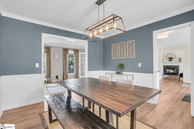 16 Chariot Ln, Simpsonville, SC 29681 - dining space featuring light wood-style floors, ornamental molding, a premium fireplace, a chandelier, and wainscoting