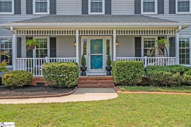 16 Chariot Ln, Simpsonville, SC 29681 - view of exterior entry featuring covered porch, a yard, and a shingled roof