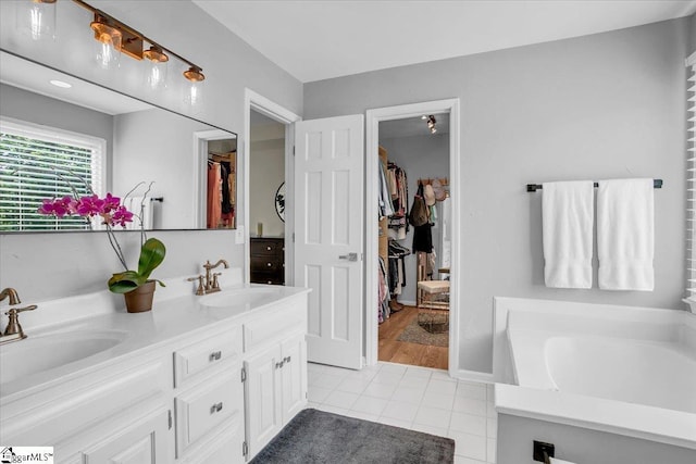 16 Chariot Ln, Simpsonville, SC 29681 - bathroom featuring double vanity, tile patterned floors, a walk in closet, and a garden tub