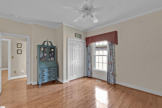 17 Bradford N Way, Greenville, SC 29617 - unfurnished bedroom with crown molding, light wood-type flooring, wallpapered walls, a ceiling fan, and a closet