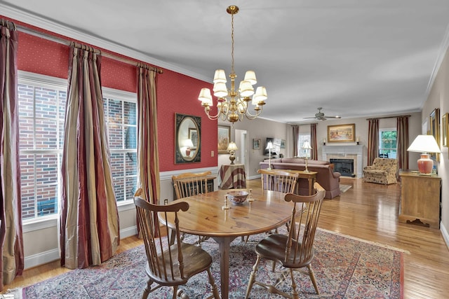 17 Bradford N Way, Greenville, SC 29617 - dining space featuring crown molding, ceiling fan, a glass covered fireplace, a chandelier, and wood finished floors