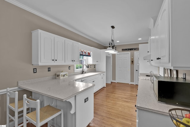 17 Bradford N Way, Greenville, SC 29617 - kitchen featuring a peninsula, crown molding, white cabinets, a sink, and light countertops