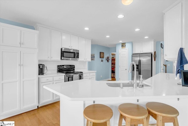 30 Chalice Hill Ln, Travelers Rest, SC 29690 - kitchen with appliances with stainless steel finishes, a peninsula, a kitchen bar, a sink, and white cabinetry