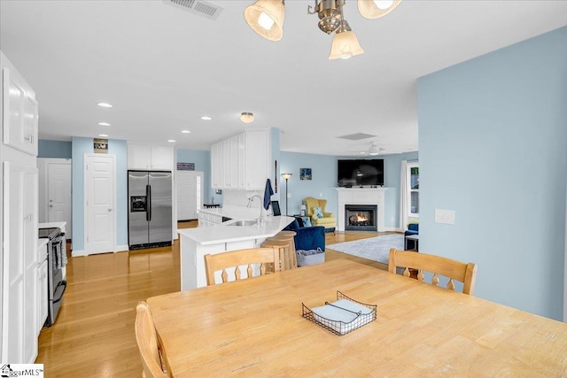 30 Chalice Hill Ln, Travelers Rest, SC 29690 - dining space featuring light wood-style flooring, a lit fireplace, recessed lighting, and a ceiling fan