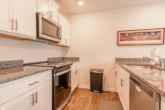304 Oakmont Valley Trl, Seneca, SC 29678 - kitchen featuring stainless steel appliances, a sink, light wood-style flooring, white cabinetry, and light stone counters