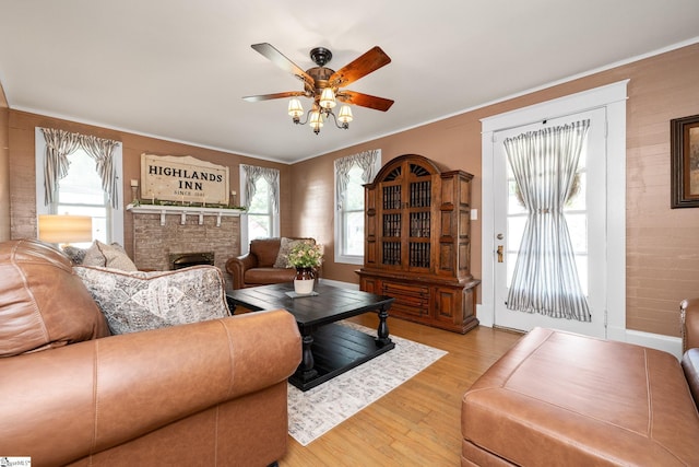 201 W Highland Ave, Anderson, SC 29625 - living room featuring light wood-type flooring, a ceiling fan, a fireplace, crown molding, and baseboards
