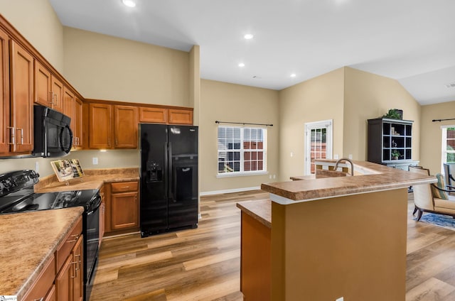 101 Peaks Ct, Taylors, SC 29687 - kitchen featuring black appliances, light wood-style floors, brown cabinets, a center island with sink, and recessed lighting