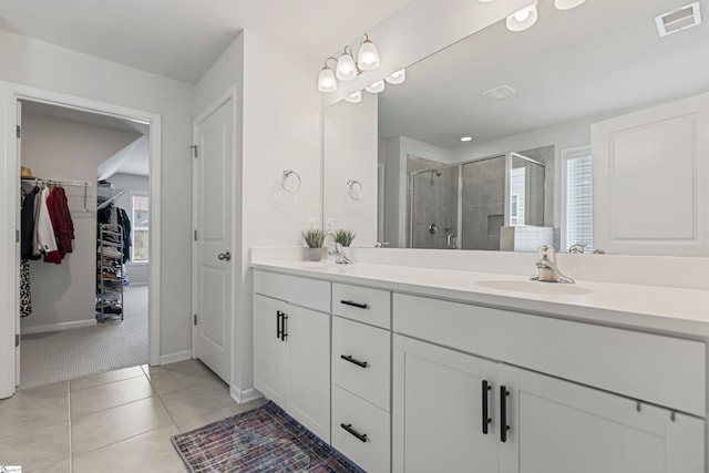 712 Paxton Rose Dr, Greer, SC 29650 - bathroom featuring double vanity, a shower stall, a spacious closet, tile patterned floors, and baseboards