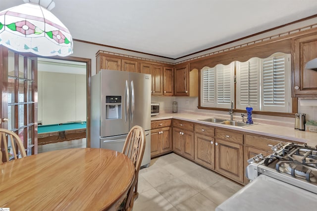 101 Myrtle St, Lavonia, GA 30553 - kitchen with appliances with stainless steel finishes, a sink, brown cabinetry, light countertops, and ornamental molding