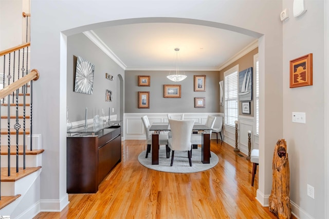 9 Windswept Knoll Dr, Taylors, SC 29687 - dining space featuring arched walkways, light wood-style flooring, stairs, and ornamental molding