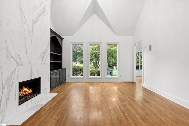 601 Brixton Cir, Simpsonville, SC 29681 - unfurnished living room with a high end fireplace, light wood finished floors, baseboards, and high vaulted ceiling