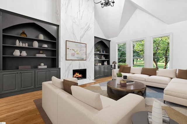 601 Brixton Cir, Simpsonville, SC 29681 - living room featuring light wood finished floors, built in features, a fireplace, and high vaulted ceiling