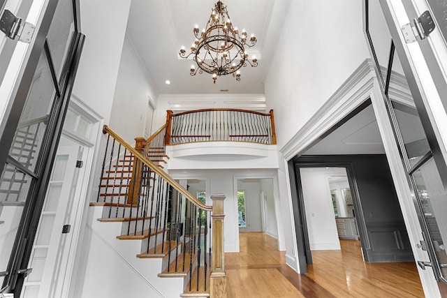 601 Brixton Cir, Simpsonville, SC 29681 - foyer entrance featuring a towering ceiling, a chandelier, ornamental molding, wood finished floors, and stairs