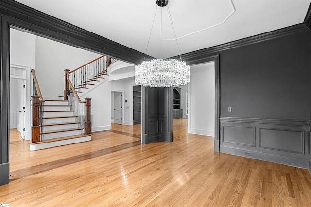 601 Brixton Cir, Simpsonville, SC 29681 - unfurnished dining area featuring stairs, a chandelier, wood finished floors, arched walkways, and crown molding