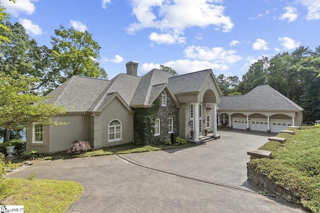 33 Southview Ledge Rd, Landrum, SC 29356 - view of front of home with asphalt driveway, an attached garage, a chimney, stucco siding, and stone siding