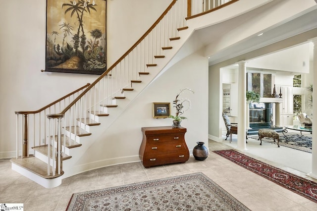 33 Southview Ledge Rd, Landrum, SC 29356 - staircase featuring tile patterned floors, baseboards, a towering ceiling, and ornate columns