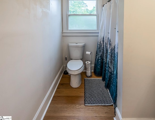 6913 White Horse Rd, Greenville, SC 29611 - bathroom with wood finished floors, toilet, baseboards, and a shower with curtain