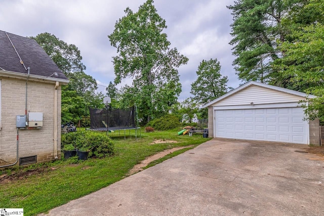 6913 White Horse Rd, Greenville, SC 29611 - view of green lawn with a trampoline, an outbuilding, and a garage
