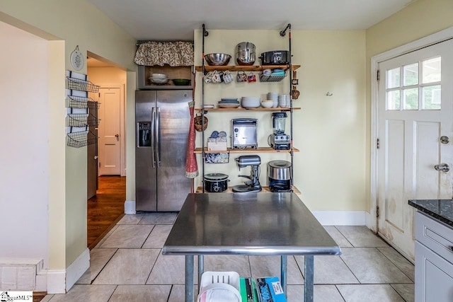 6913 White Horse Rd, Greenville, SC 29611 - kitchen featuring stainless steel fridge, light tile patterned flooring, baseboards, and dark stone countertops