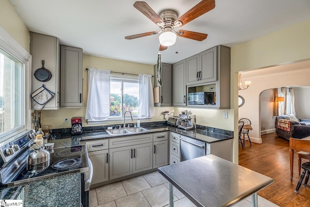 6913 White Horse Rd, Greenville, SC 29611 - kitchen featuring a sink, stainless steel appliances, gray cabinets, dark countertops, and arched walkways