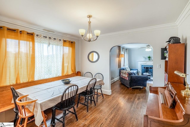6913 White Horse Rd, Greenville, SC 29611 - dining room featuring arched walkways, healthy amount of natural light, crown molding, a tiled fireplace, and wood finished floors