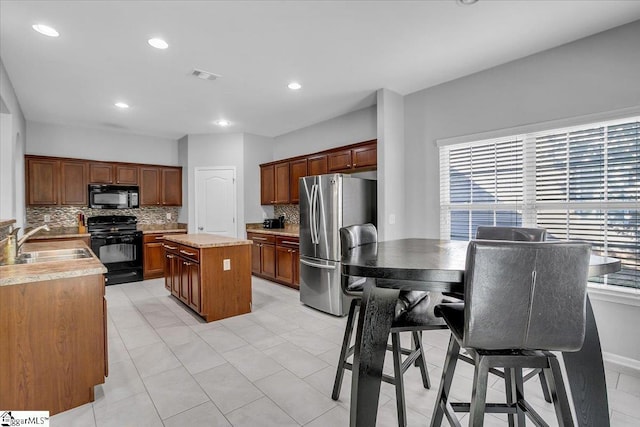 102 Eagle Pass Dr, Taylors, SC 29687 - kitchen with black appliances, a sink, tasteful backsplash, a kitchen island, and light countertops