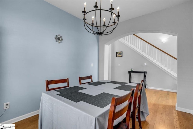 102 Eagle Pass Dr, Taylors, SC 29687 - dining room with arched walkways, a chandelier, wood finished floors, stairway, and baseboards