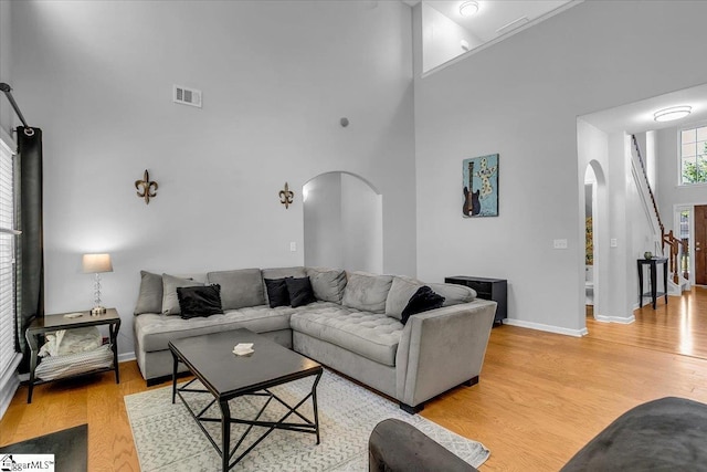 102 Eagle Pass Dr, Taylors, SC 29687 - living area with arched walkways, a high ceiling, light wood-style floors, and baseboards