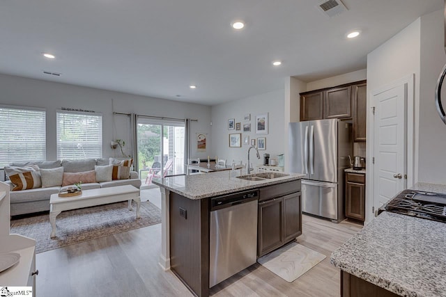 404 Hillrock Ct, Greenville, SC 29617 - kitchen featuring appliances with stainless steel finishes, a sink, light wood-type flooring, dark brown cabinets, and open floor plan