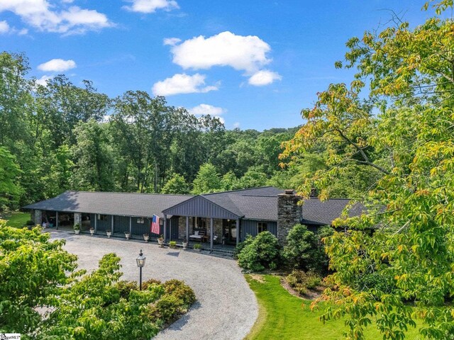 11 Hearthstone Ln, Landrum, SC 29356 - view of front of house featuring a chimney, curved driveway, and a wooded view