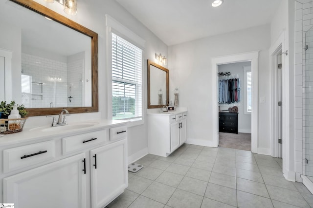 706 Torridon Ln, Simpsonville, SC 29681 - bathroom with two vanities, a shower stall, tile patterned floors, a walk in closet, and baseboards