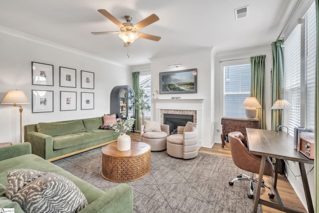 706 Torridon Ln, Simpsonville, SC 29681 - living room featuring wood finished floors, a glass covered fireplace, a ceiling fan, and ornamental molding