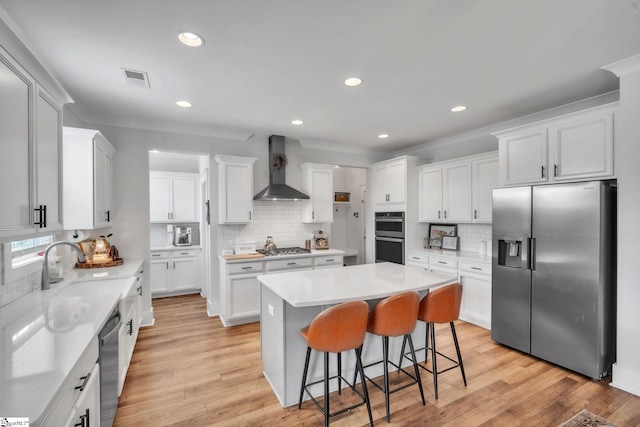 706 Torridon Ln, Simpsonville, SC 29681 - kitchen with stainless steel appliances, wall chimney exhaust hood, a kitchen island, tasteful backsplash, and recessed lighting